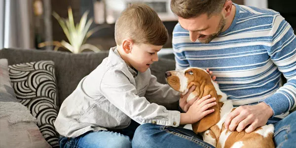 Father and son playing with dog